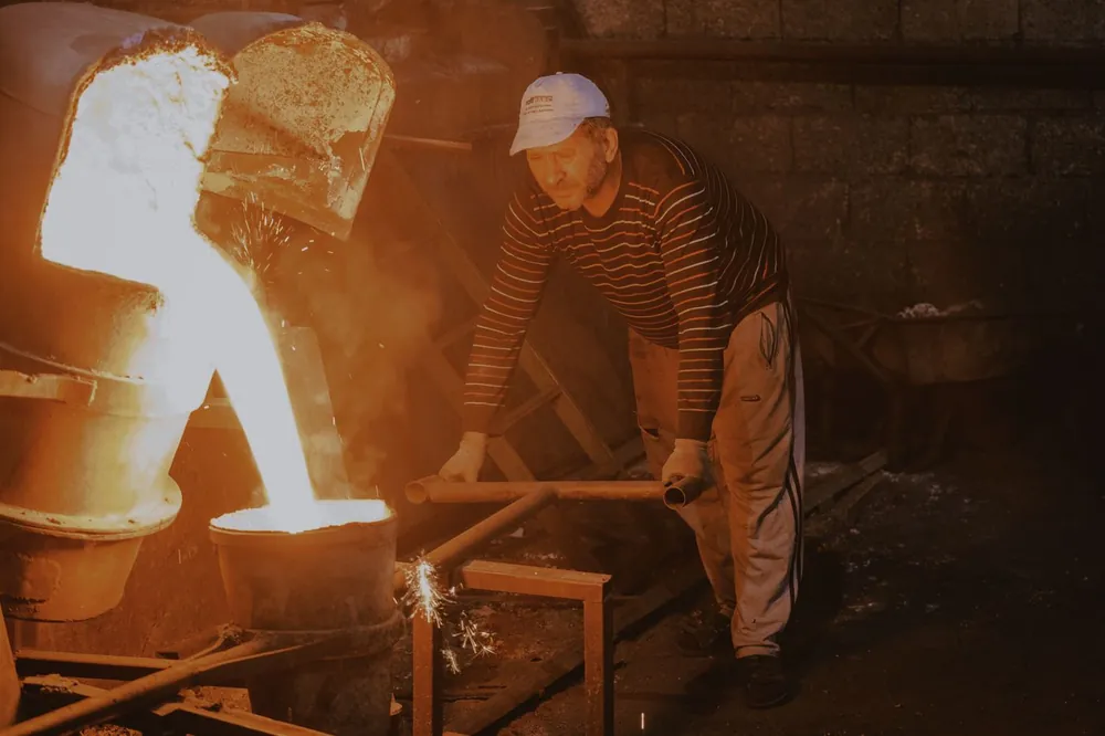 Foundry worker handling molten metal